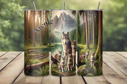 Customizable tumbler featuring a wolf pack standing near a peaceful forest lake with towering mountains in the background, personalized with a name up to 12 characters.